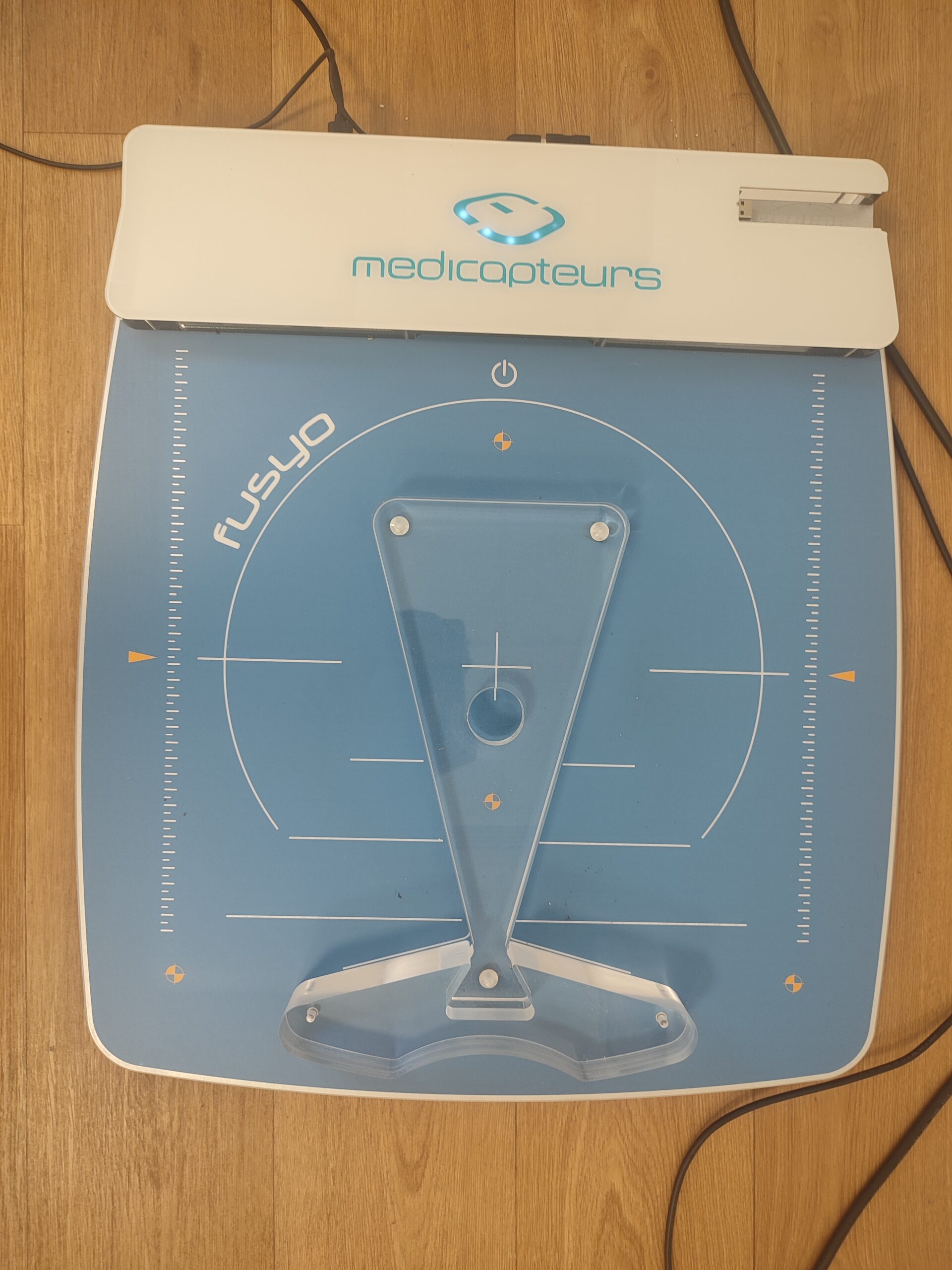 Patient sur la plateforme de stabilométrie normée du cabinet lors d'un examen de posturographie